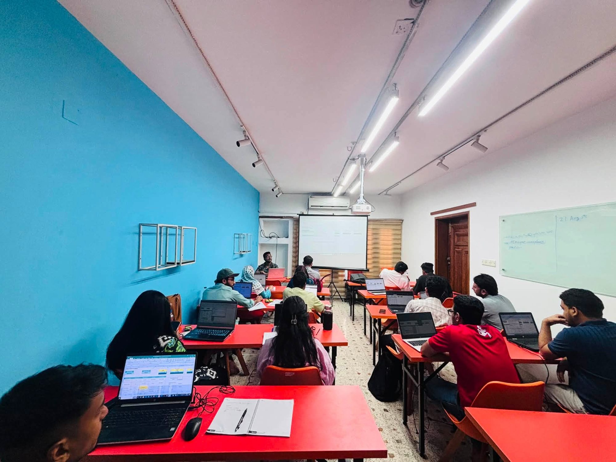 A Data Solution 360 class at Mohakhali DOHS: learners at laptops following the instructor's screen